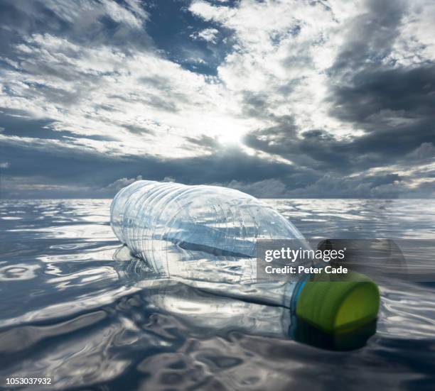 plastic bottle floating in ocean - plastic microbeads stock pictures, royalty-free photos & images