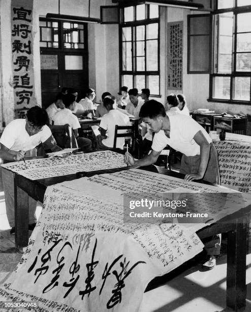 Pinceau à la main, deux jeunes professeurs rédigent les affiches de propagande du Parti communiste chinois, en Chine, le 21 septembre 1967.