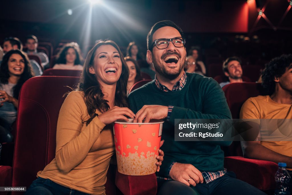 Happy couple eating popcorn