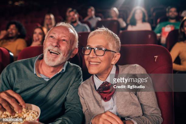 lächelnde paar im kino - filmindustrie stock-fotos und bilder
