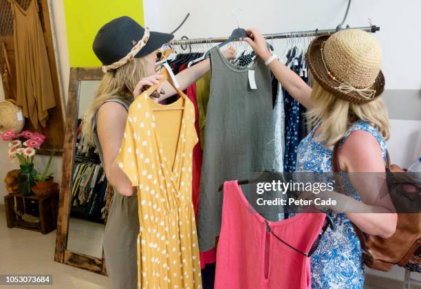 mother and daughter shopping in clothes shop - clothing store stockfoto's en -beelden