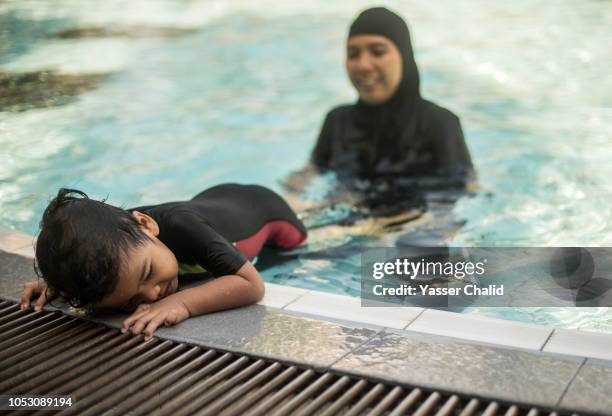 mother teaching her son how  to swim - burkini bildbanksfoton och bilder