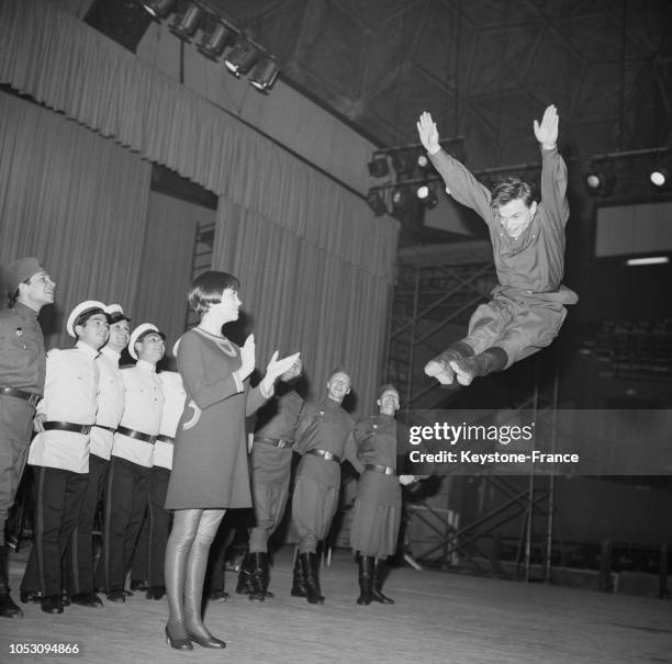 Mireille Mathieu admirant le saut d'un danseur de la troupe des choeurs de l'Armée rouge au Palais des Sports, à Paris, France, le 23 novembre 1967.