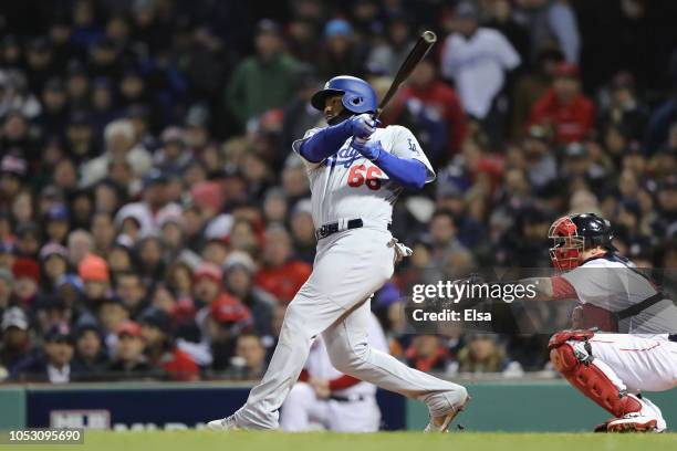 Yasiel Puig of the Los Angeles Dodgers hits an RBI single during the fourth inning against the Boston Red Sox in Game Two of the 2018 World Series at...