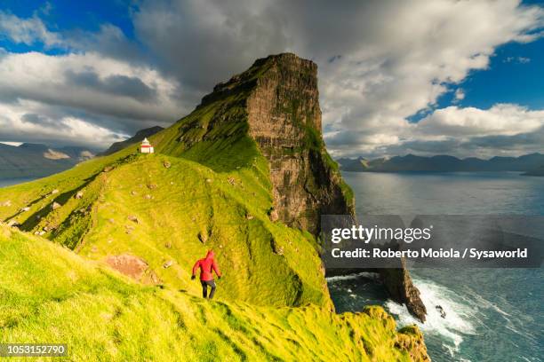 hiker towards kallur lighthouse, kalsoy island - headland stock pictures, royalty-free photos & images