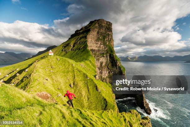 hiker on cliffs, kallur lighthouse, faroe islands - belize stock pictures, royalty-free photos & images