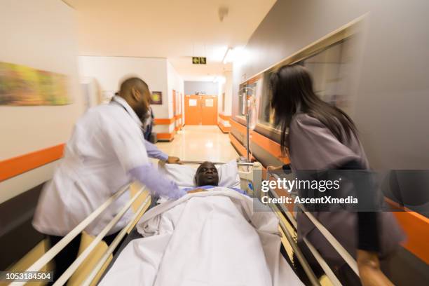 rushing a patient to the emergency room - emergency room doctors pushing patient on gurney blurred motion stock pictures, royalty-free photos & images