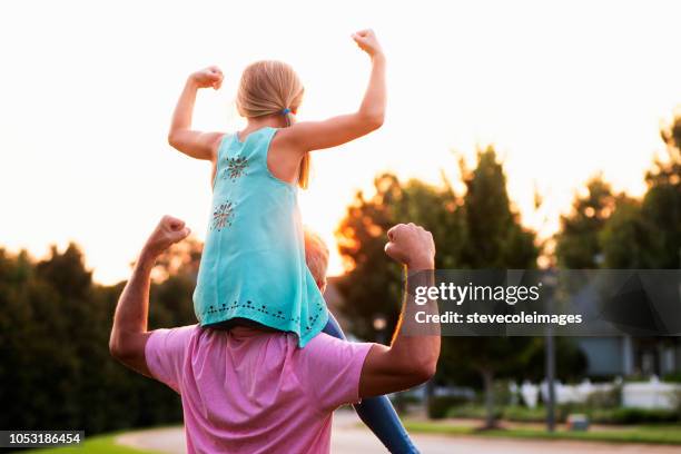 figlia che flette i muscoli con il padre - flexing muscles foto e immagini stock