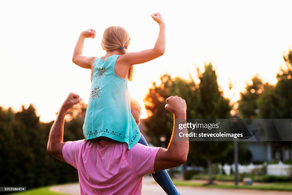 Daughter Flexing Muscles with Father