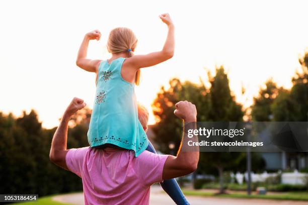 daughter flexing muscles with father - posterior view of arm muscles stock pictures, royalty-free photos & images