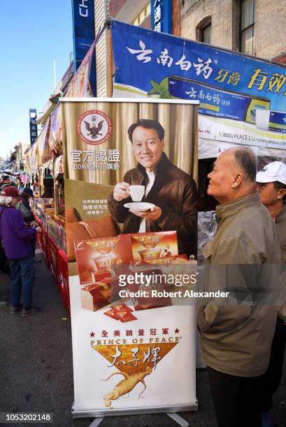 Booth at a street festival in Chinatown, San Francisco, California, promotes and sells herbal tea made from ginseng grown in Wisconsin, USA. The...