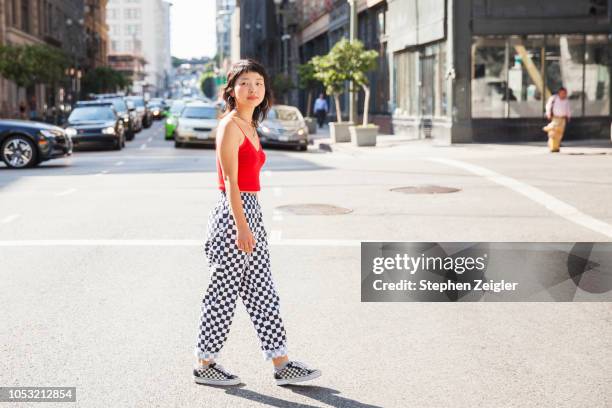 young woman crossing a city street - korean people stock pictures, royalty-free photos & images