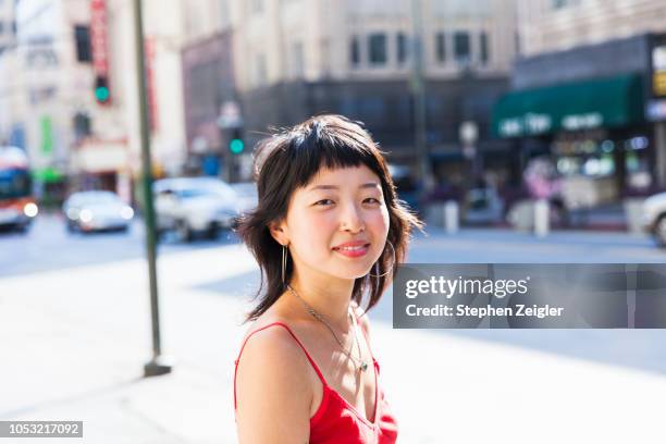 young woman looking at camera smiling - koreanischer abstammung stock-fotos und bilder