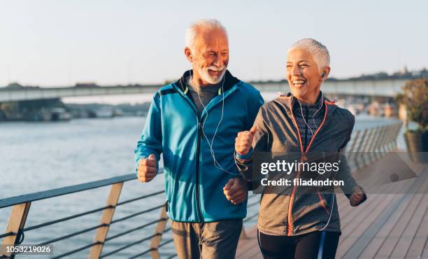 älteres paar joggen - paar in sportkleidung stock-fotos und bilder