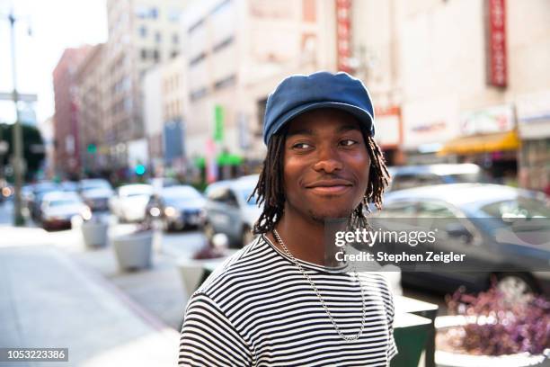 portrait of young man on city street - chico ciudad fotografías e imágenes de stock