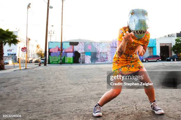 woman wearing a dinosaur mask - mask joke stockfoto's en -beelden