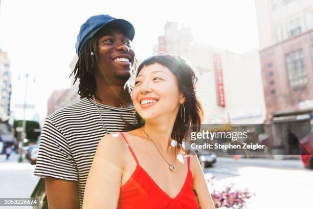 young couple on city street - young adult couple stock pictures, royalty-free photos & images