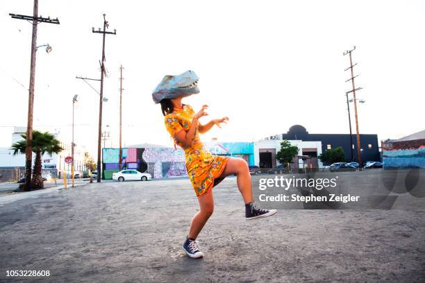 woman wearing a dinosaur mask - créativité photos et images de collection