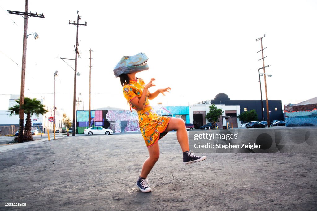 Woman wearing a dinosaur mask