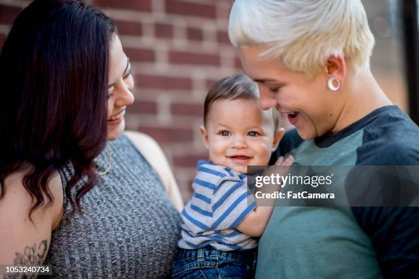 若い同性カップルが彼らの男の子に崇拝し笑顔します。 - baby　smile ストックフォトと画像