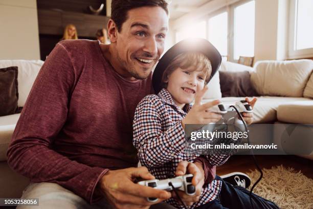 zoon en vader spelen-station gebruiken - game four stockfoto's en -beelden