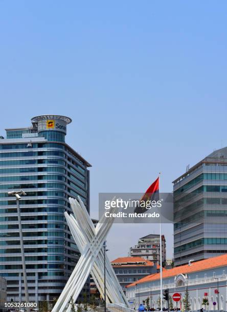 luanda - unknown soldier memorial in front of the central post office and flanked by two buildings of sonangol - waterfront avenue - angola - angola flag stock pictures, royalty-free photos & images