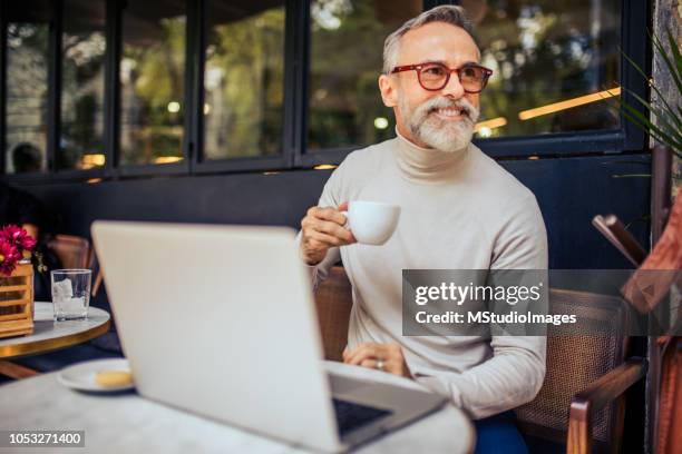 handsome mature adult relaxing at the bar. - bar drink establishment stock pictures, royalty-free photos & images