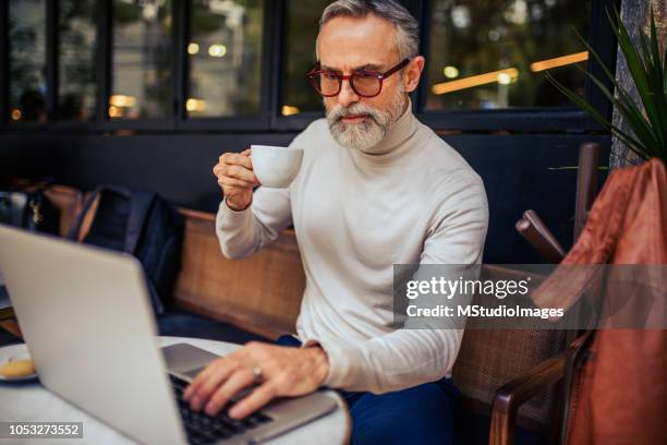 handsome mature adult using laptop. - bar drink establishment stock pictures, royalty-free photos & images
