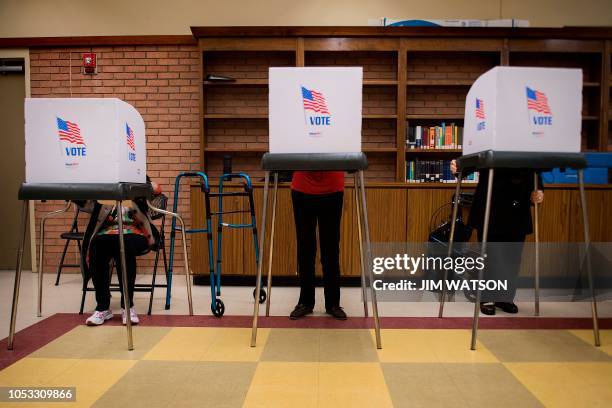 Iva Woke , a 100-year-old resident living in Chestertown, Maryland, casts he ballot in a voting booth as others do the same at the Kent County Public...