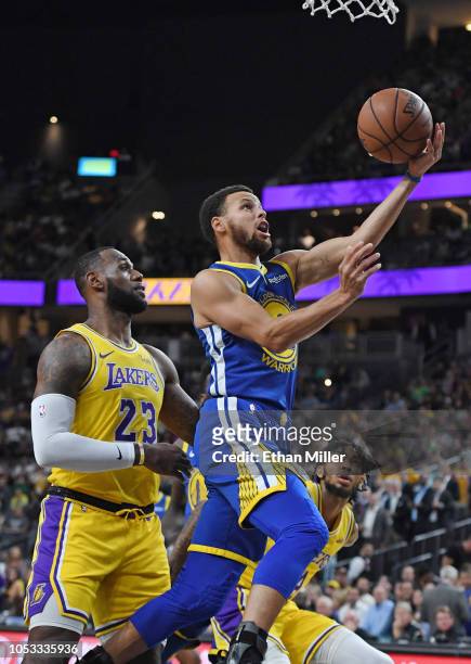 Stephen Curry of the Golden State Warriors drives to the basket ahead of LeBron James of the Los Angeles Lakers during their preseason game at...