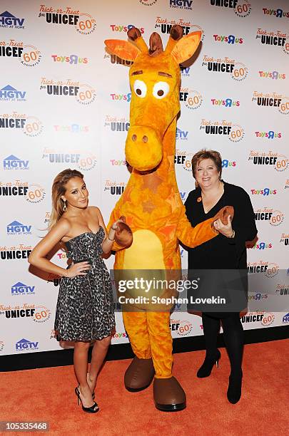 Actress Adrienne Bailon, Toys "R" Us mascot Geoffrey the Giraffe, and U.S. Fund for UNICEF President and CEO Caryl Stern attend Trick-or-Treat for...