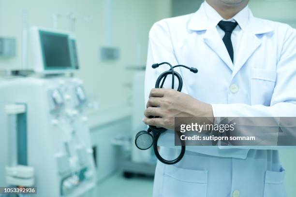 medical care and healthcare doctor holding a stethoscope in uniform gown - doctor lab coat stockfoto's en -beelden