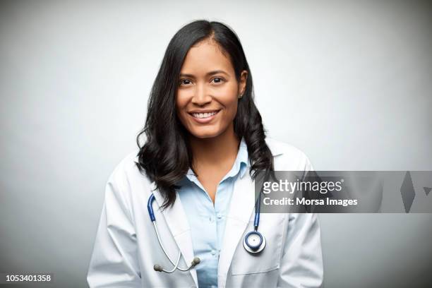 female doctor smiling over white background - laboratoriumjas stockfoto's en -beelden