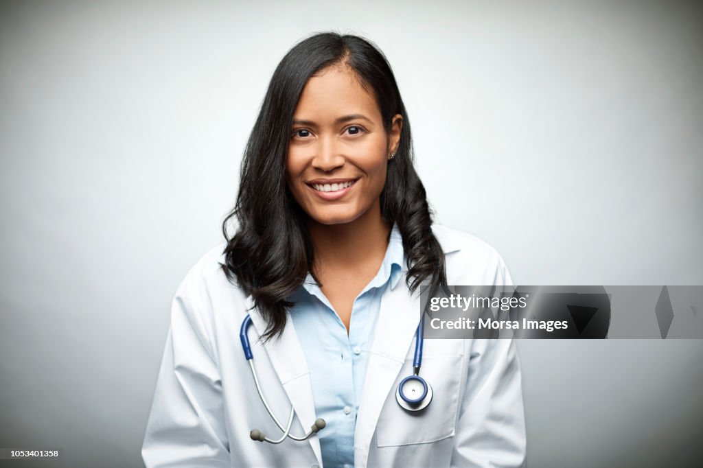 Female doctor smiling over white background