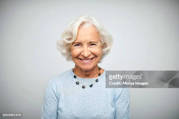 senior businesswoman smiling on white background - donne anziane foto e immagini stock