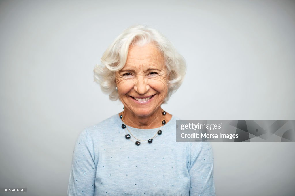 Senior businesswoman smiling on white background