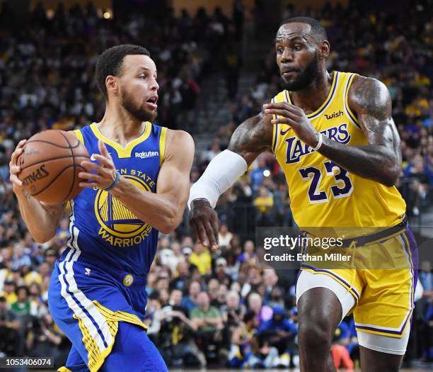 Stephen Curry of the Golden State Warriors drives against LeBron James of the Los Angeles Lakers during their preseason game at T-Mobile Arena on...