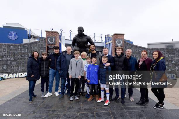 Andre Gomes of Everton poses for a photograph with fans before surprises a young Everton fan with a trip to the club shop at Goodison Park on October...