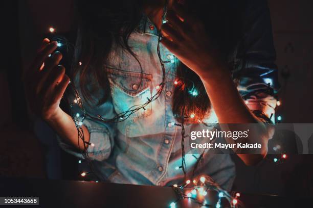 midsection of girl holding string lights in her hand - christmas cool attitude stock pictures, royalty-free photos & images