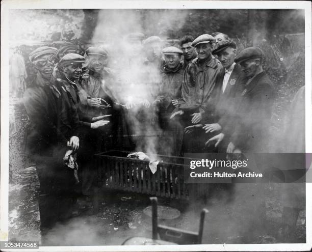 Workers warming their hands around a brazier during a General Strike England.