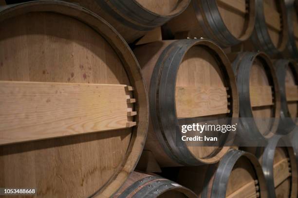 oak wine barrels stacked in winery cellar - weinfass stock-fotos und bilder