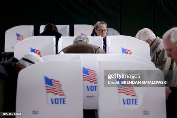 People cast their ballots at a community center during early voting October 25, 2018 in Potomac, Maryland, two weeks ahead of the key US midterm...