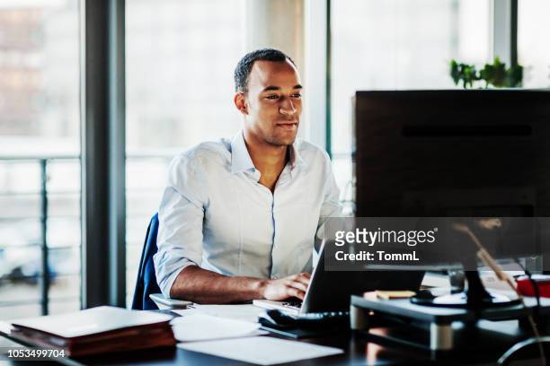 office manager working on computer at his desk - using computer stock pictures, royalty-free photos & images