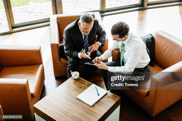 two business partners looking at digital tablet - arial view business meeting stock pictures, royalty-free photos & images