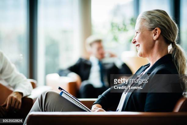 mature business owner listening during meeting - corporate business owner stock pictures, royalty-free photos & images