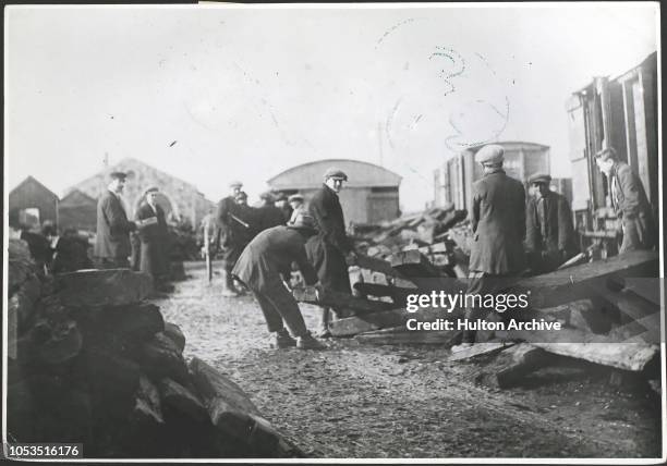 Relief train being unloaded at a railway station in the west of Ireland during a famine, February 1925 - it consists of old railway sleepers...
