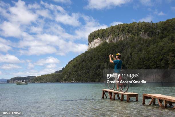 male bicyclist dock mountain lake - bariloche argentina stock pictures, royalty-free photos & images