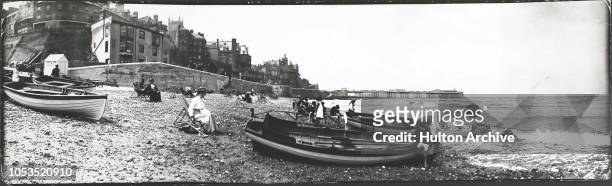 Boats on the beach at Cromer, Norfolk, with the pier in the background, circa 1900.