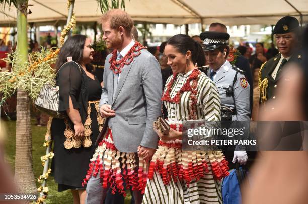 Britain's Prince Harry and his wife Meghan, the Duchess of Sussex visit a craft fair in Nuku'alo in Tonga on October 26, 2018. - Prince Harry and his...