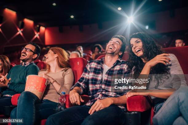 junge leute lachen im kino - filmindustrie stock-fotos und bilder